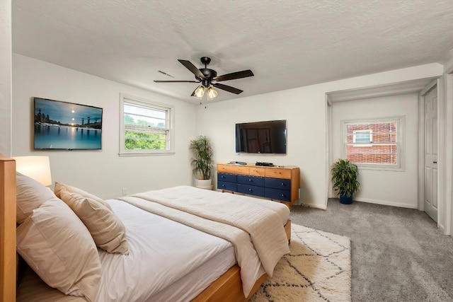 bedroom with light colored carpet, ceiling fan, and a textured ceiling