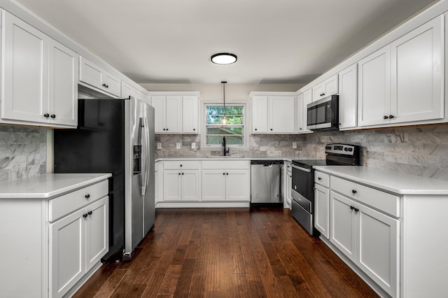 kitchen featuring sink, appliances with stainless steel finishes, white cabinetry, and hanging light fixtures