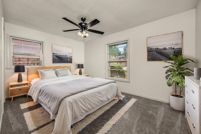 bedroom with ceiling fan and dark colored carpet