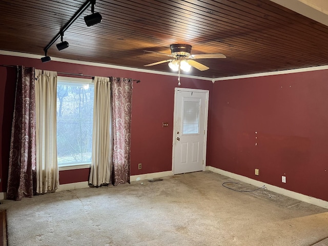 empty room with wood ceiling, ceiling fan, ornamental molding, and carpet floors