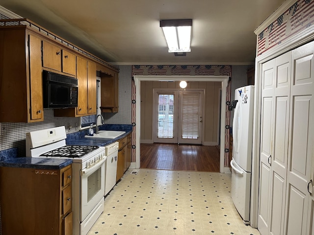 kitchen featuring crown molding, sink, and white appliances