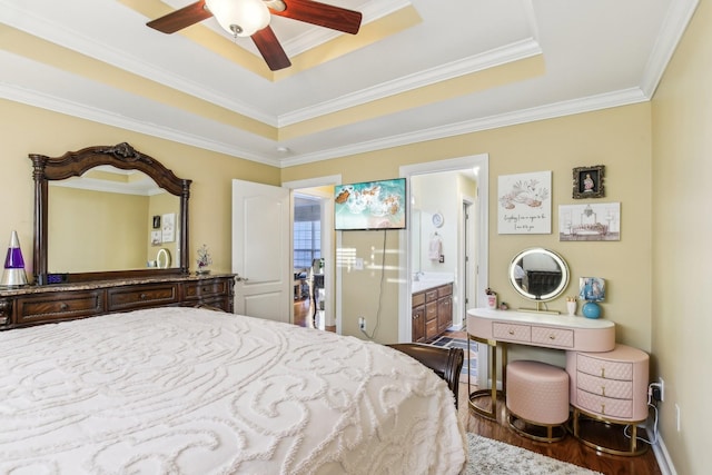 bedroom with ceiling fan, crown molding, ensuite bath, and a tray ceiling