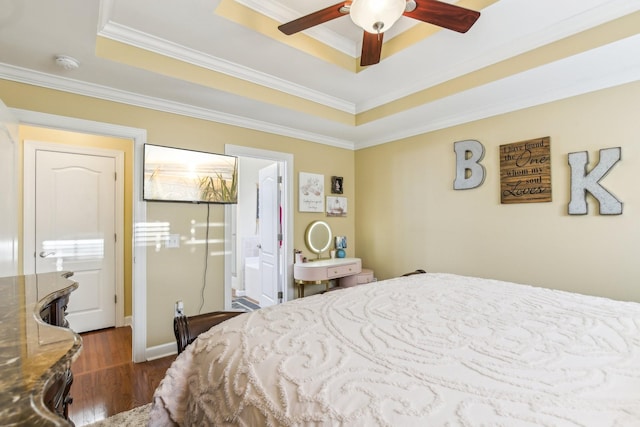 bedroom with ensuite bathroom, ceiling fan, a tray ceiling, and ornamental molding