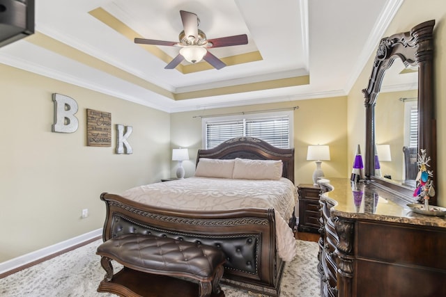 bedroom with ceiling fan, hardwood / wood-style floors, and a raised ceiling