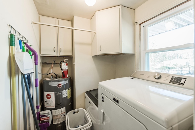 laundry area with water heater, cabinets, and separate washer and dryer