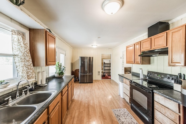 kitchen featuring black / electric stove, light hardwood / wood-style floors, stainless steel refrigerator, ornamental molding, and sink