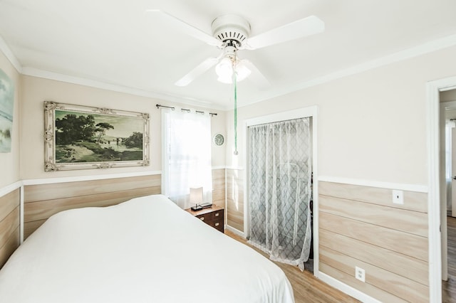 bedroom featuring ceiling fan, hardwood / wood-style flooring, and crown molding