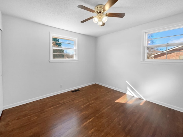 empty room with ceiling fan, a textured ceiling, and dark hardwood / wood-style floors