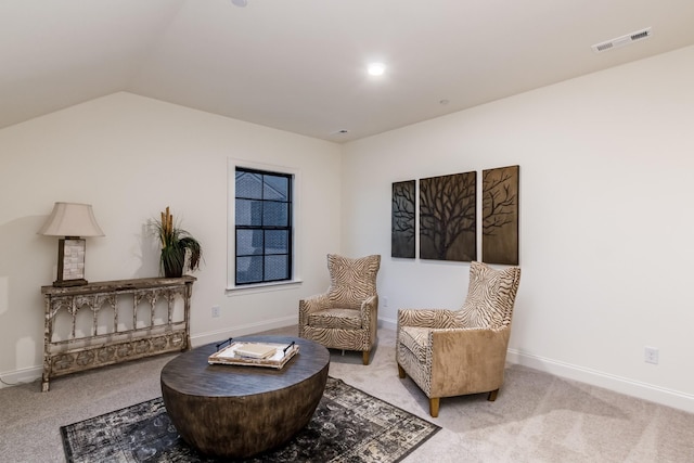 living area featuring vaulted ceiling and light carpet