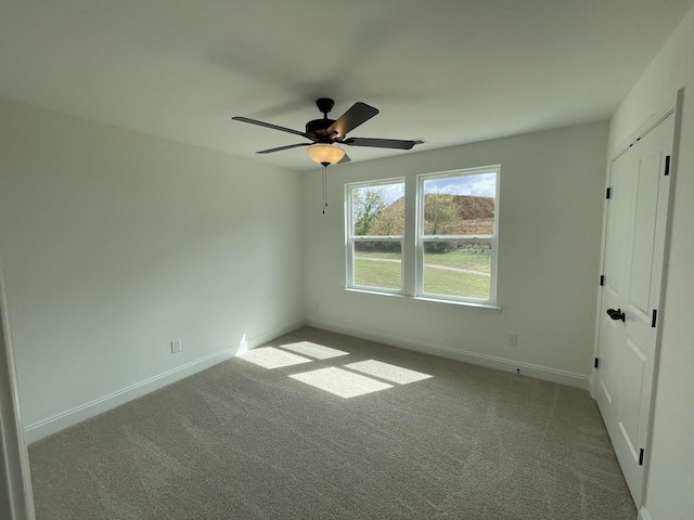 carpeted spare room with ceiling fan