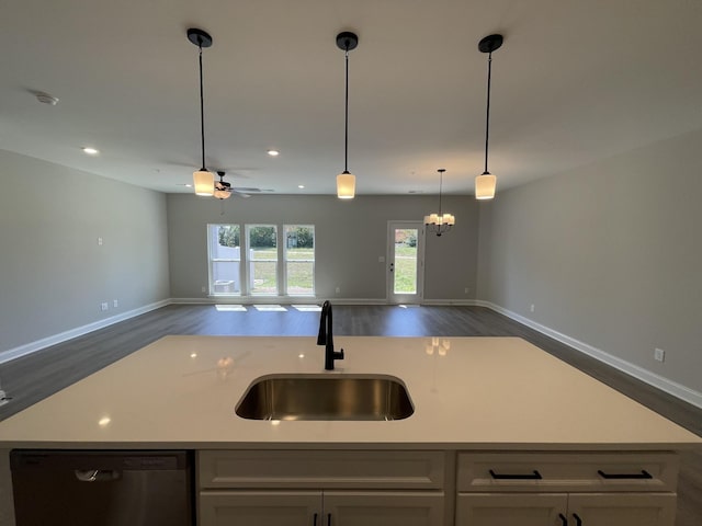 kitchen with dishwasher, pendant lighting, an island with sink, ceiling fan with notable chandelier, and sink