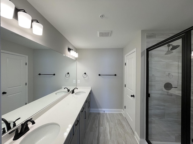 bathroom featuring a shower with door and vanity