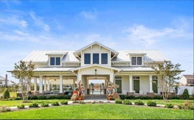 back of property with a lawn and a porch