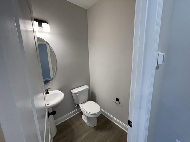 bathroom with toilet and wood-type flooring