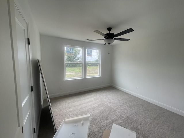 empty room with ceiling fan and carpet