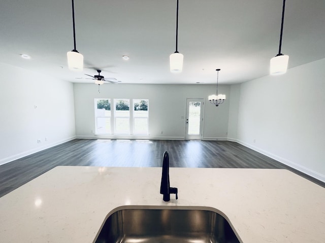 kitchen with ceiling fan with notable chandelier, sink, pendant lighting, and dark hardwood / wood-style floors