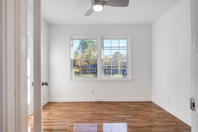 empty room with ceiling fan and hardwood / wood-style flooring