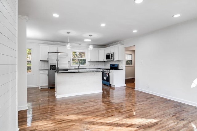 kitchen with a center island, white cabinetry, pendant lighting, plenty of natural light, and appliances with stainless steel finishes