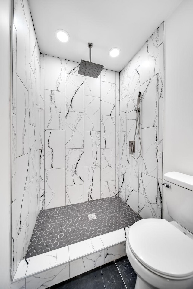 bathroom featuring a tile shower and toilet