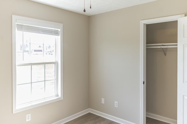 unfurnished bedroom featuring dark wood-type flooring and a closet