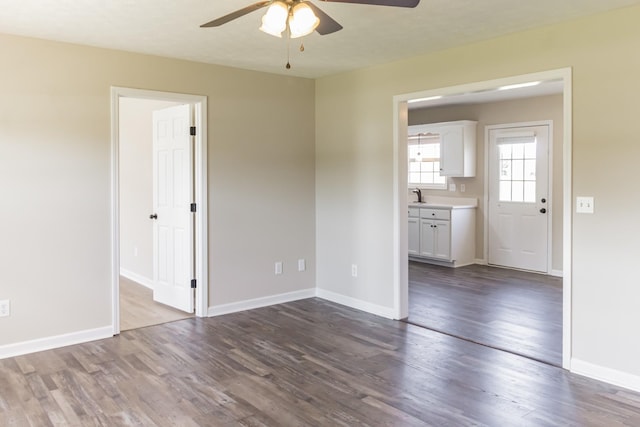 spare room featuring ceiling fan, sink, and wood-type flooring