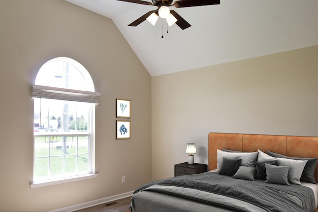 bedroom featuring lofted ceiling, ceiling fan, and multiple windows