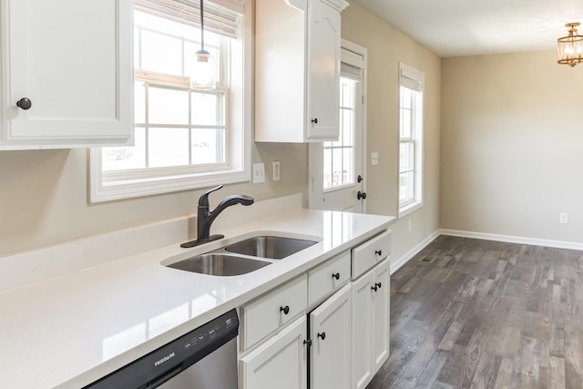 kitchen featuring pendant lighting, dark hardwood / wood-style flooring, white cabinets, stainless steel dishwasher, and sink