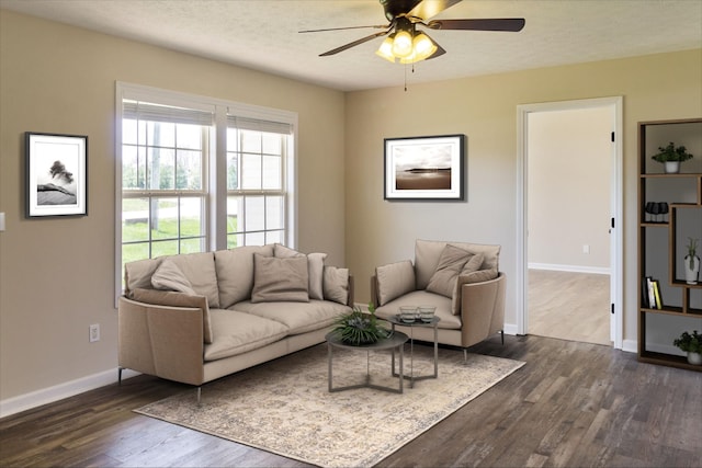 living room featuring ceiling fan and dark hardwood / wood-style flooring