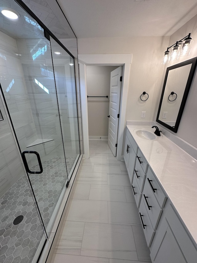 bathroom with a shower with door and vanity