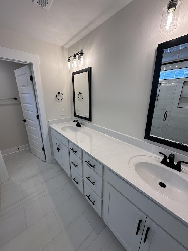 bathroom featuring a shower with door, tile patterned floors, and vanity