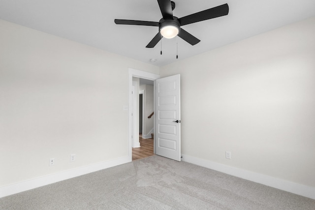 spare room with ceiling fan and light colored carpet