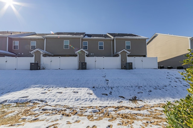 snow covered property featuring central AC unit