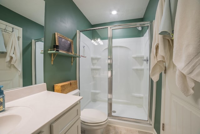 bathroom featuring toilet, a textured ceiling, an enclosed shower, and vanity