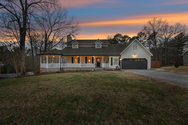 view of front of property featuring a yard, covered porch, and a garage