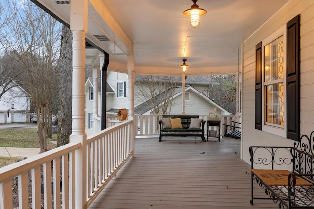 deck with ceiling fan and covered porch