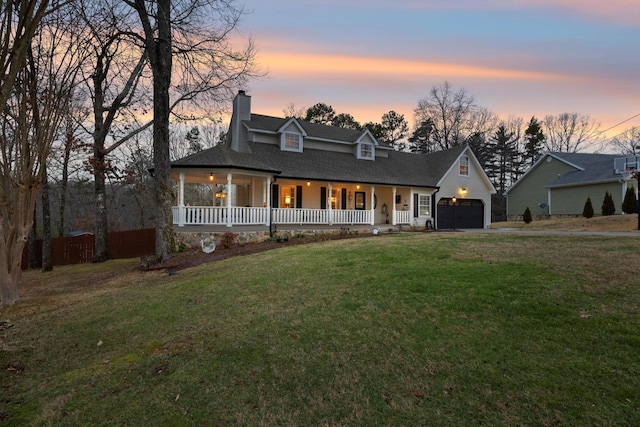 view of front of house with a porch, a yard, and a garage