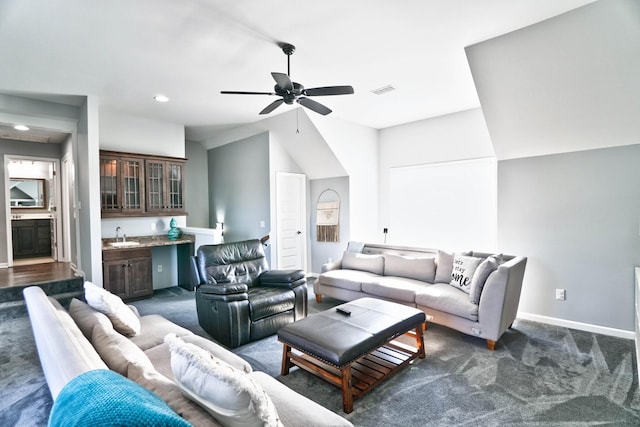 carpeted living room with lofted ceiling, ceiling fan, and sink