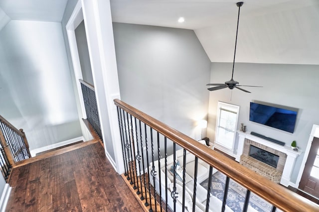 corridor with hardwood / wood-style floors and vaulted ceiling