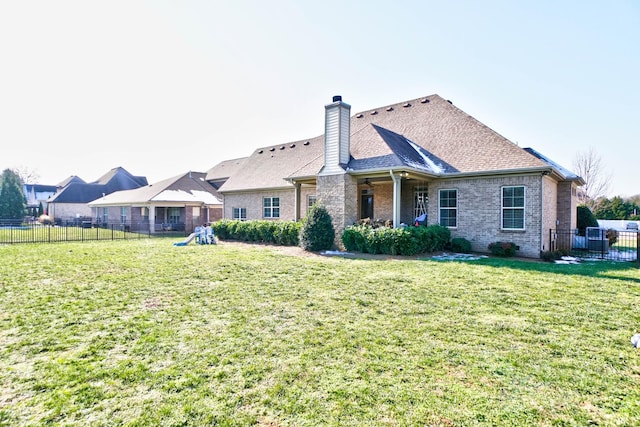 rear view of property with a yard