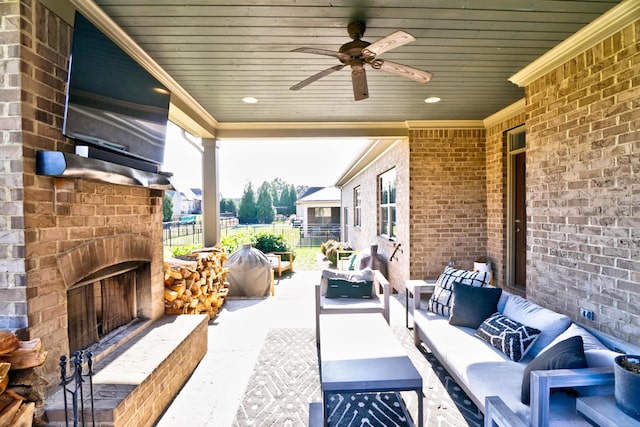 view of patio with ceiling fan and an outdoor living space with a fireplace