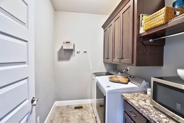 laundry room featuring independent washer and dryer, cabinets, and light tile patterned floors