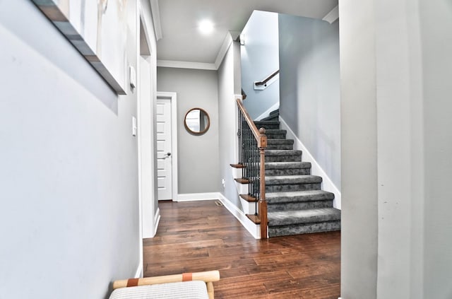 foyer with ornamental molding and dark wood-type flooring