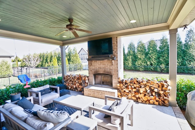 view of patio with ceiling fan and an outdoor living space with a fireplace