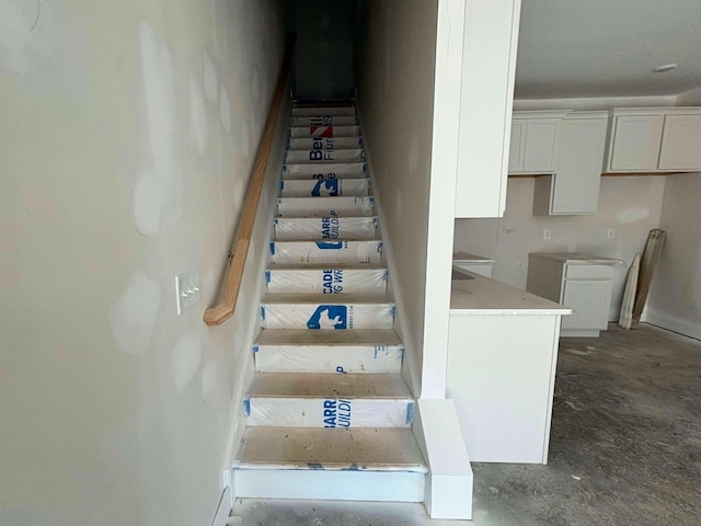 stairway featuring concrete flooring