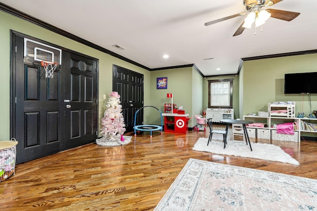 playroom featuring ceiling fan, ornamental molding, and hardwood / wood-style floors