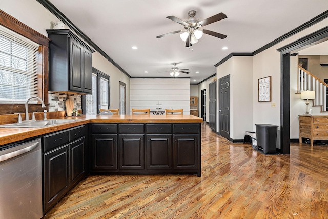 kitchen with stainless steel dishwasher, sink, ornamental molding, and light hardwood / wood-style flooring