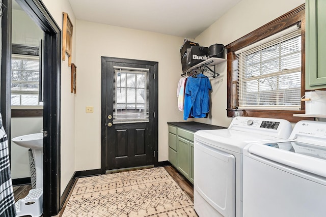 washroom with a healthy amount of sunlight, separate washer and dryer, and cabinets