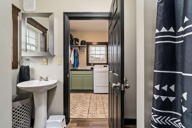 bathroom with washer / dryer, wood-type flooring, and sink