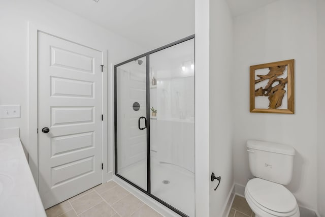 bathroom with a shower with shower door, tile patterned floors, vanity, and toilet