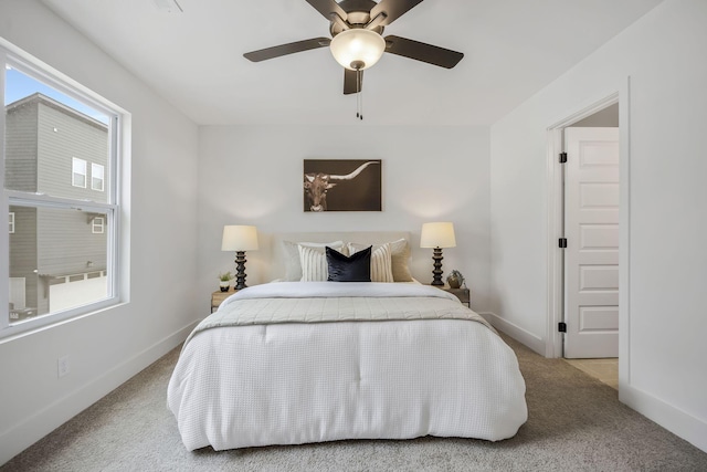 bedroom featuring ceiling fan, light carpet, and multiple windows